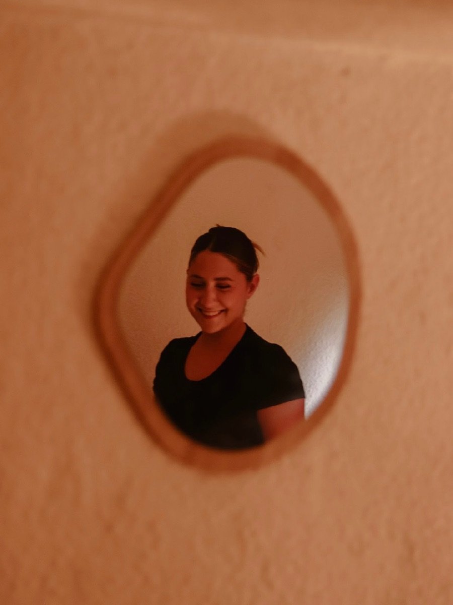 Clémentine, praticienne en massage bien-être, souriante dans un miroir ovale